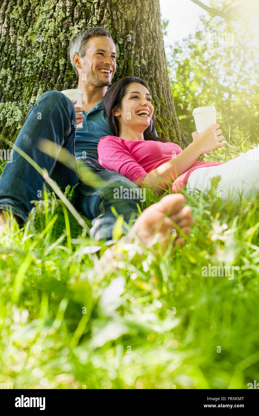 A Nice Grey Hair Man And A Woman Are Sitting In The Grass Having