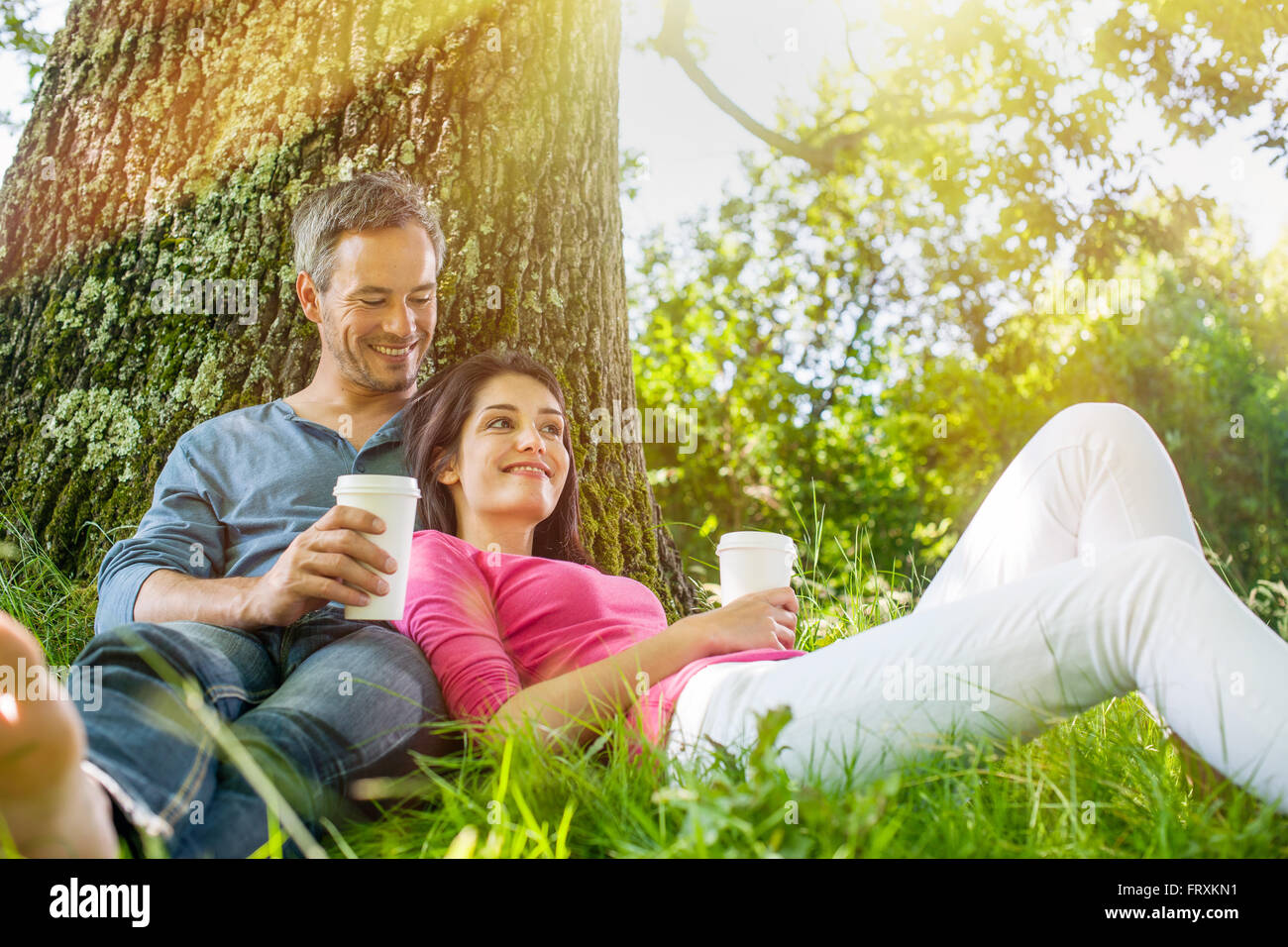 A Nice Grey Hair Man And A Woman Are Sitting In The Grass Having