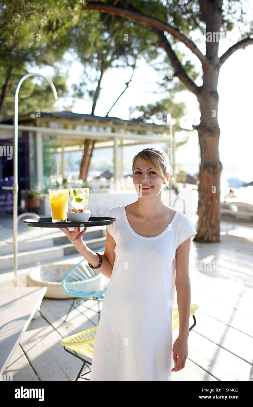 Waitress serving drinks in a hotel restaurant, Vourvourou, Sithonia, Chalkidiki, Greece Stock Photo
