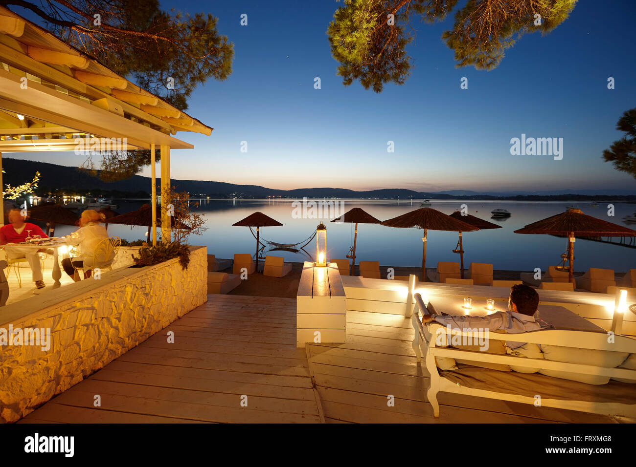 Guests in a beach bar of a hotel in the evening, Vourvourou, Sithonia, Chalkidiki, Greece Stock Photo