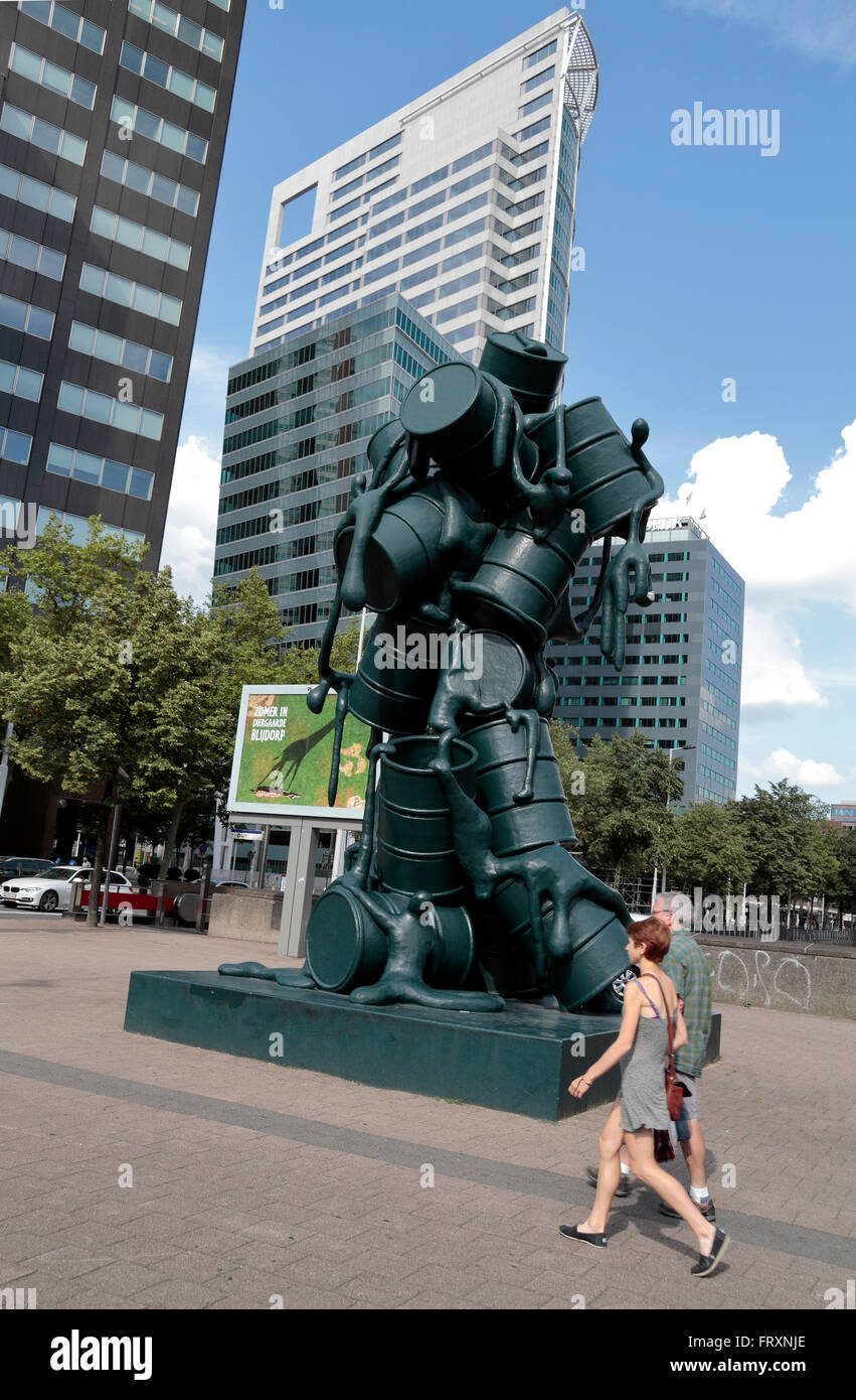 A couple walk past "Cascade", a sculpture of oil barrels by Atelier van Lieshout in Rotterdam, Netherlands. Stock Photo