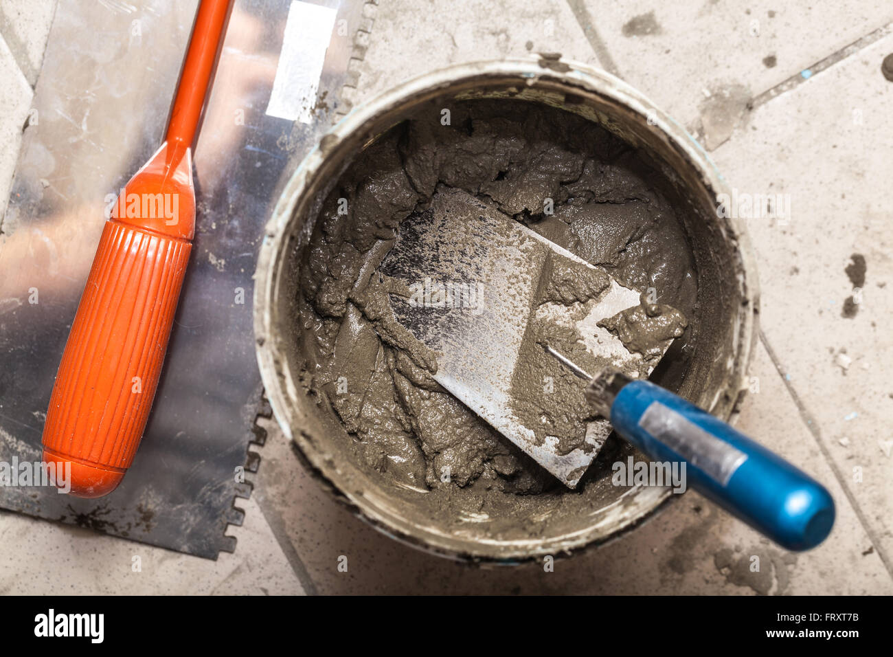 bucket with cement and trowel on tiles Stock Photo Alamy