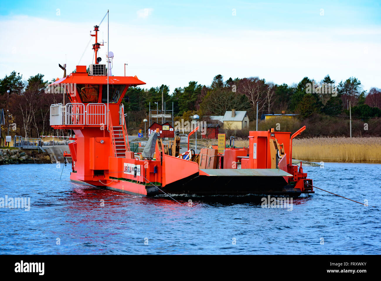 Torhamn, Sweden - March 18, 2016: The bright orange cable operated car ferry between mainland and the Ytteron island. Here seen Stock Photo