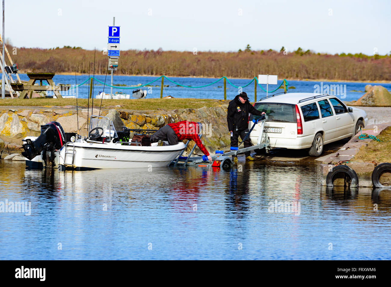 Torhamn, Sweden - March 18, 2016: The launching of a small plastic motor boat at a ramp in the marina. Boat is loaded off a trai Stock Photo
