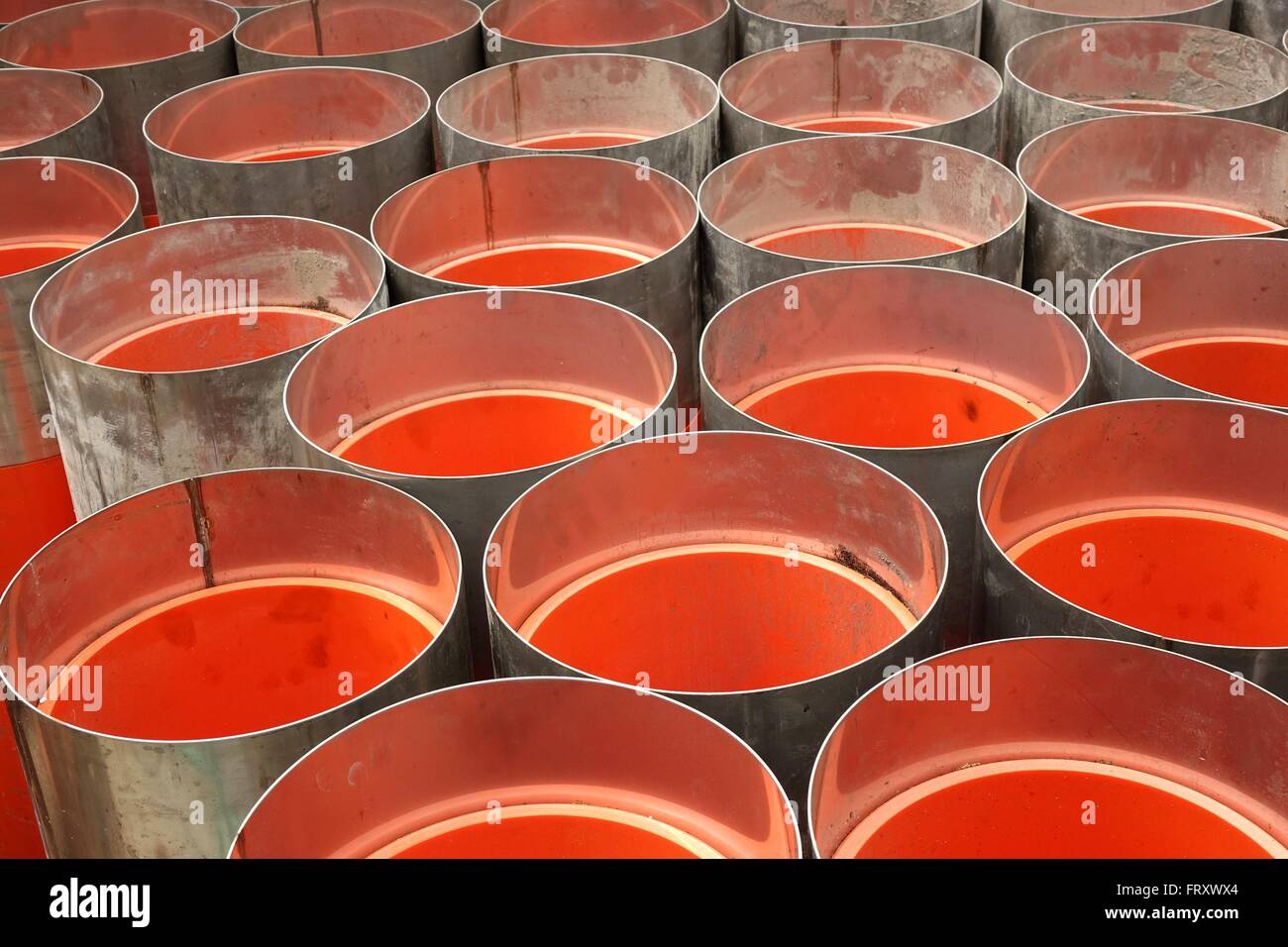 Large orange PVC pipes with stainless steel metal caps Stock Photo