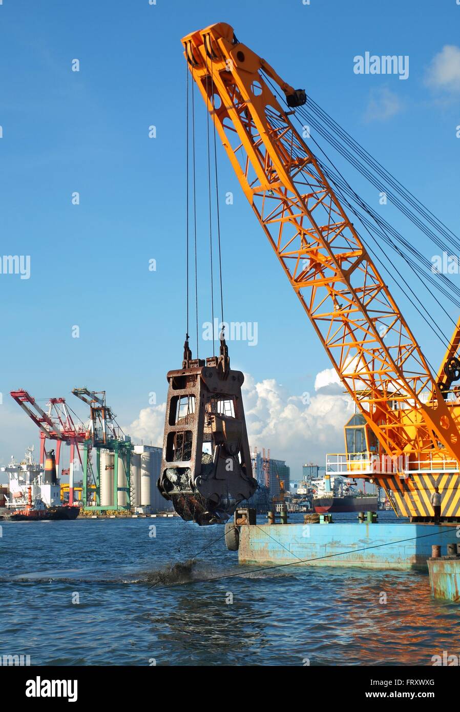 A clamshell dredger mounted on a barge in Kaohsiung port Stock Photo