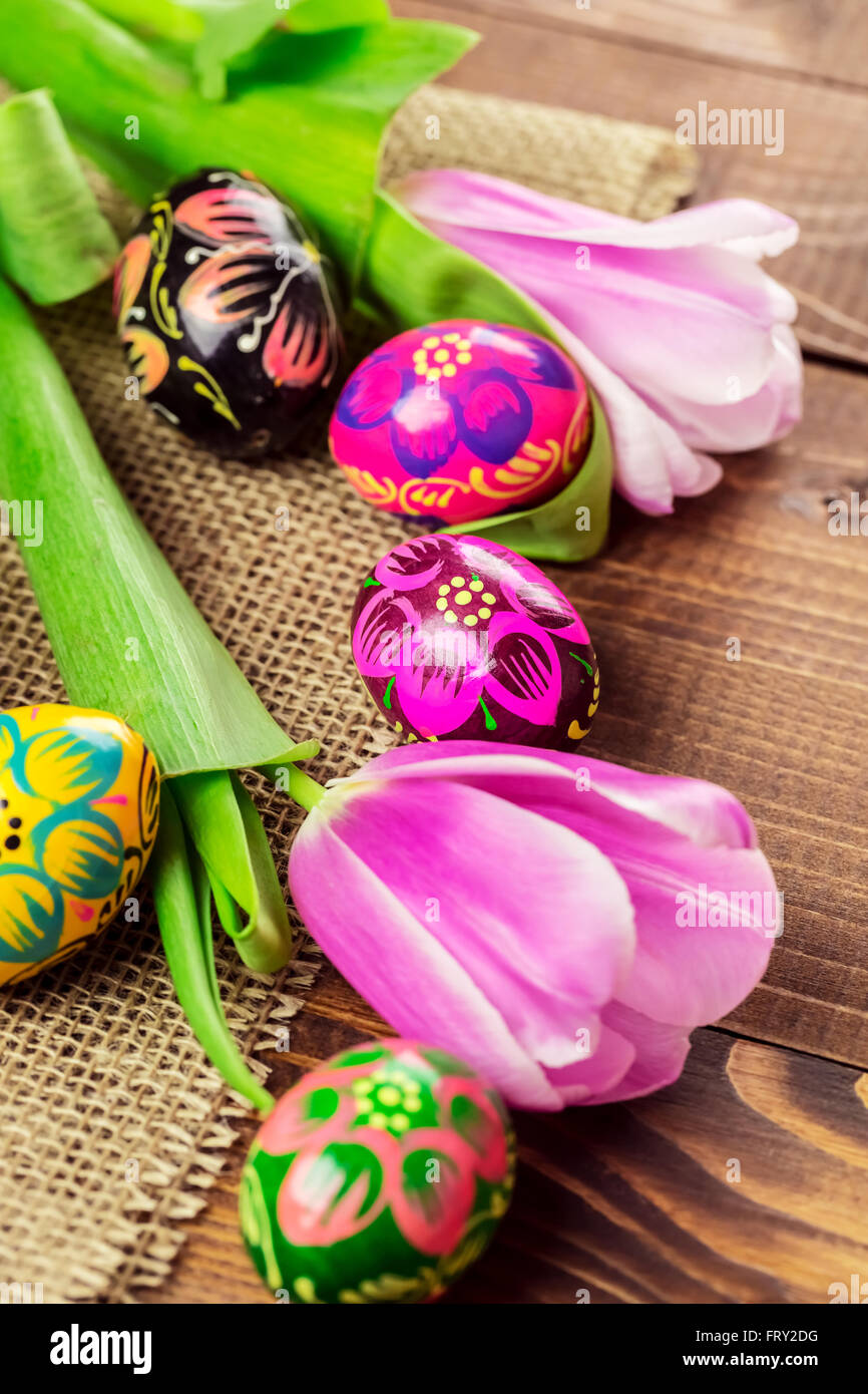 Beautiful background with painted Easter eggs and tulips laid on a ...