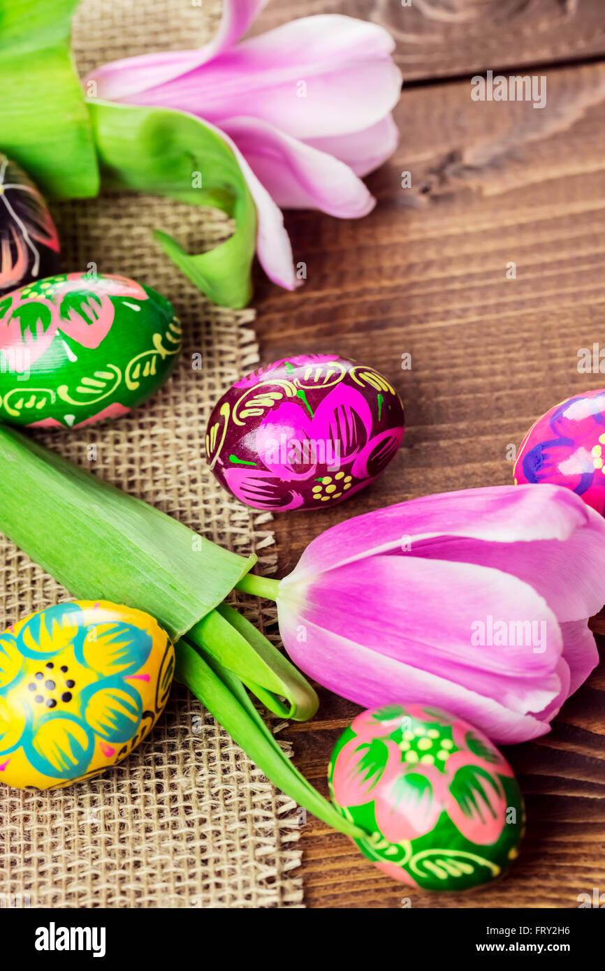Beautiful background with painted Easter eggs and tulips laid on a ...