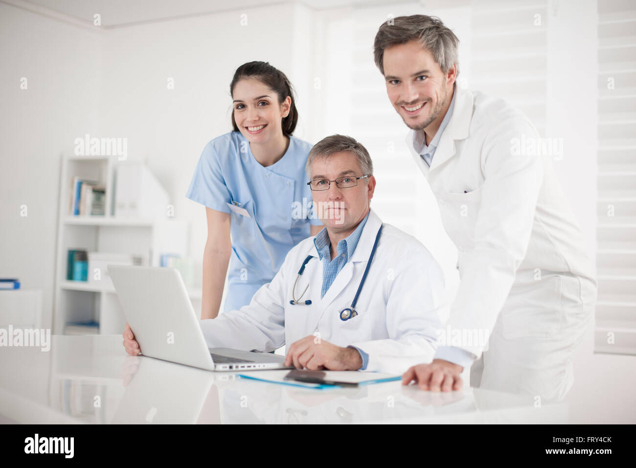 medical team discussing around a computer Stock Photo - Alamy