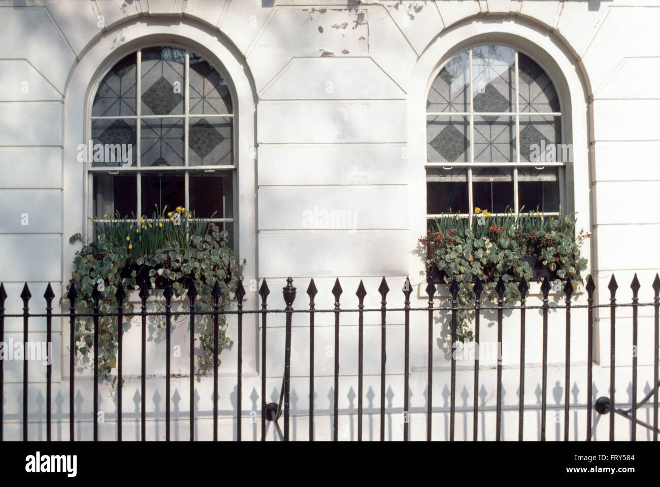 Iron railings in front of Victorian townhouse with arched windows Stock Photo