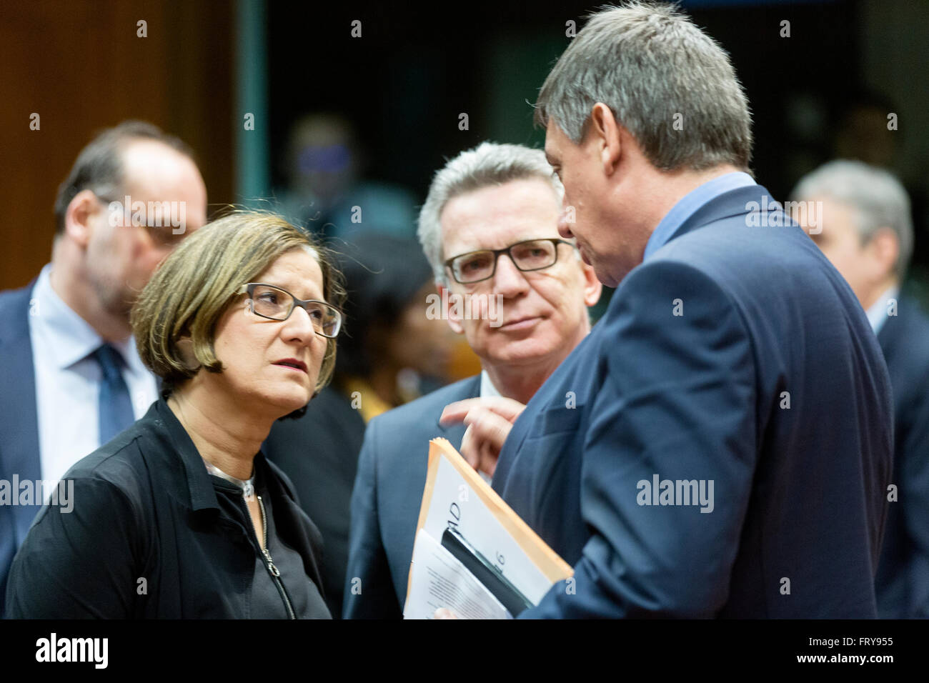 Brussels, Belgium. 24th March, 2016. Austrian Federal Minister for the Interior Johanna Mikl-Leitner (L) is talking with the German Federal Minister for the Interior Thomas de Maiziere (C) and the Belgium Deputy Prime Minister and Minister for Security and the Interior, with responsibility for the Large Cities and the Buildings Agency Jan Jambon (R) prior to an extraordinary meeting of ministers for justice and security in the EU Council headquarter. Credit:  dpa picture alliance/Alamy Live News Stock Photo