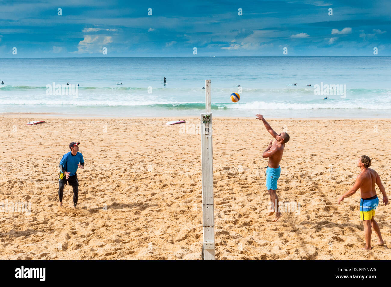 Young men play beach volleyball on a beach in Manly Sydney Australia