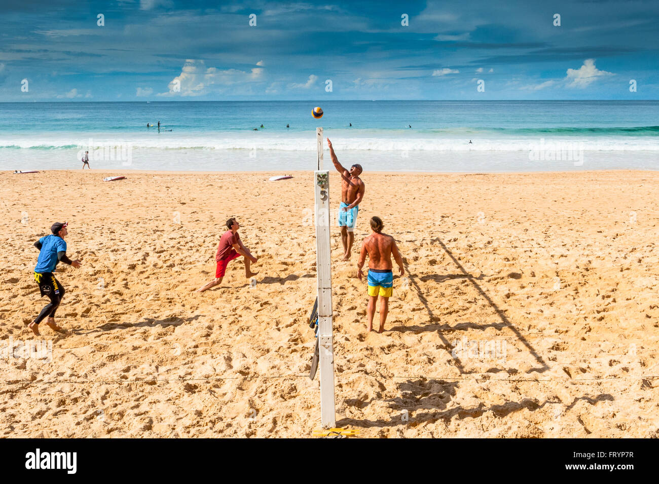 Young men play beach volleyball on a beach in Manly Sydney Australia