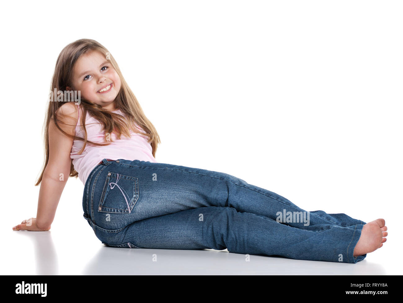 Cute happy little girl sitting on white background Stock Photo - Alamy