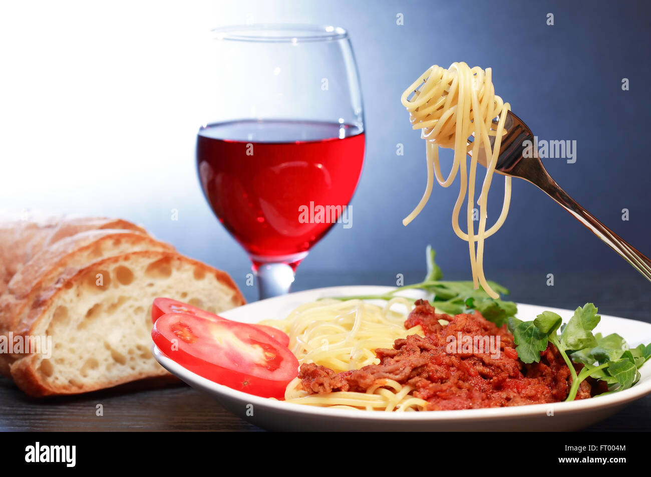Traditional Italian supper. Plate with Bolognese pasta near red wine
