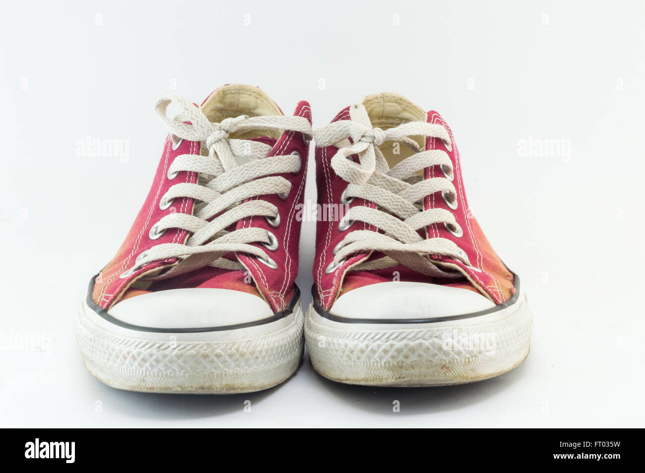 Old and dirty red sneakers on white Stock Photo
