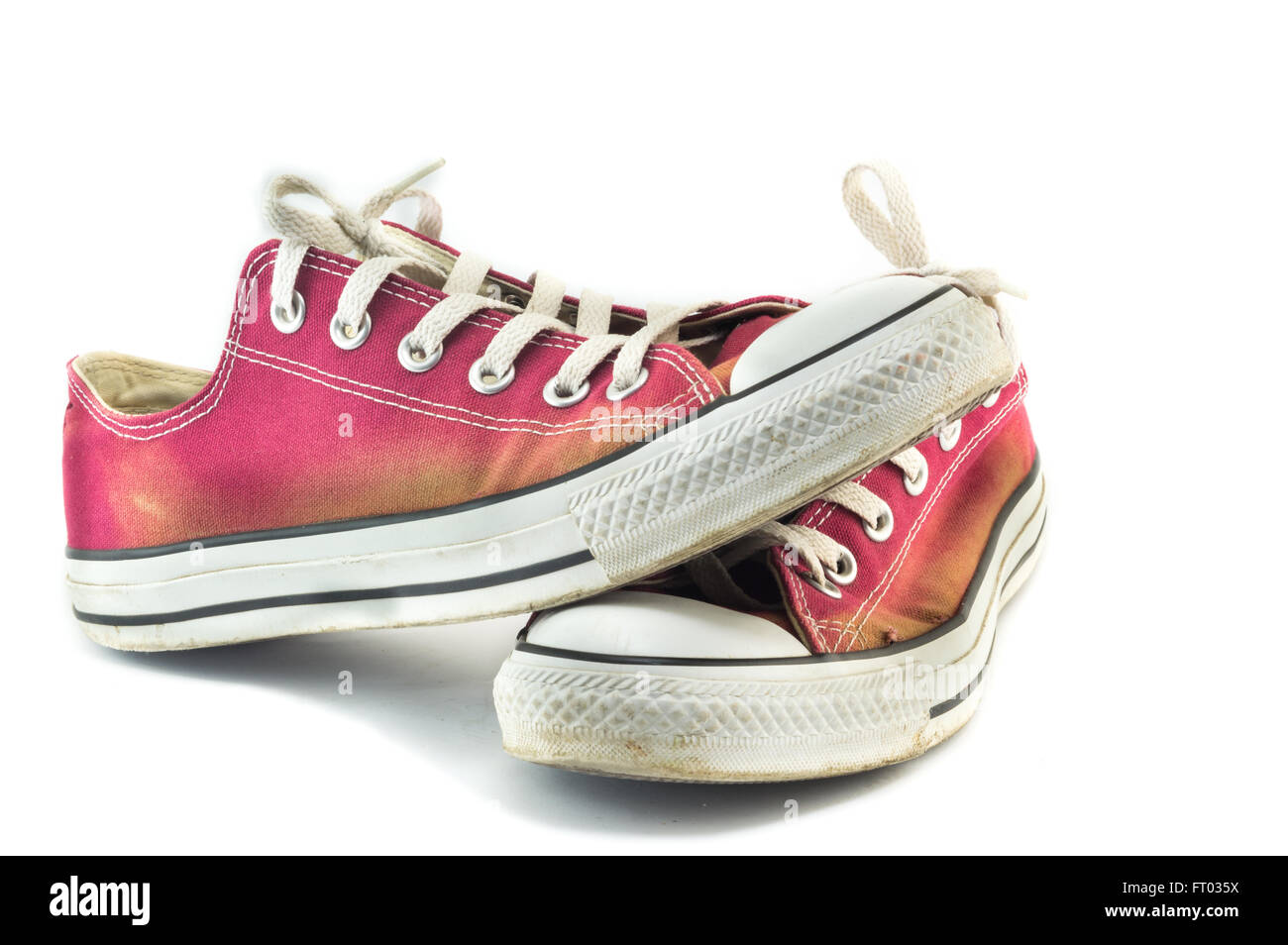 Old and dirty red sneakers on white Stock Photo