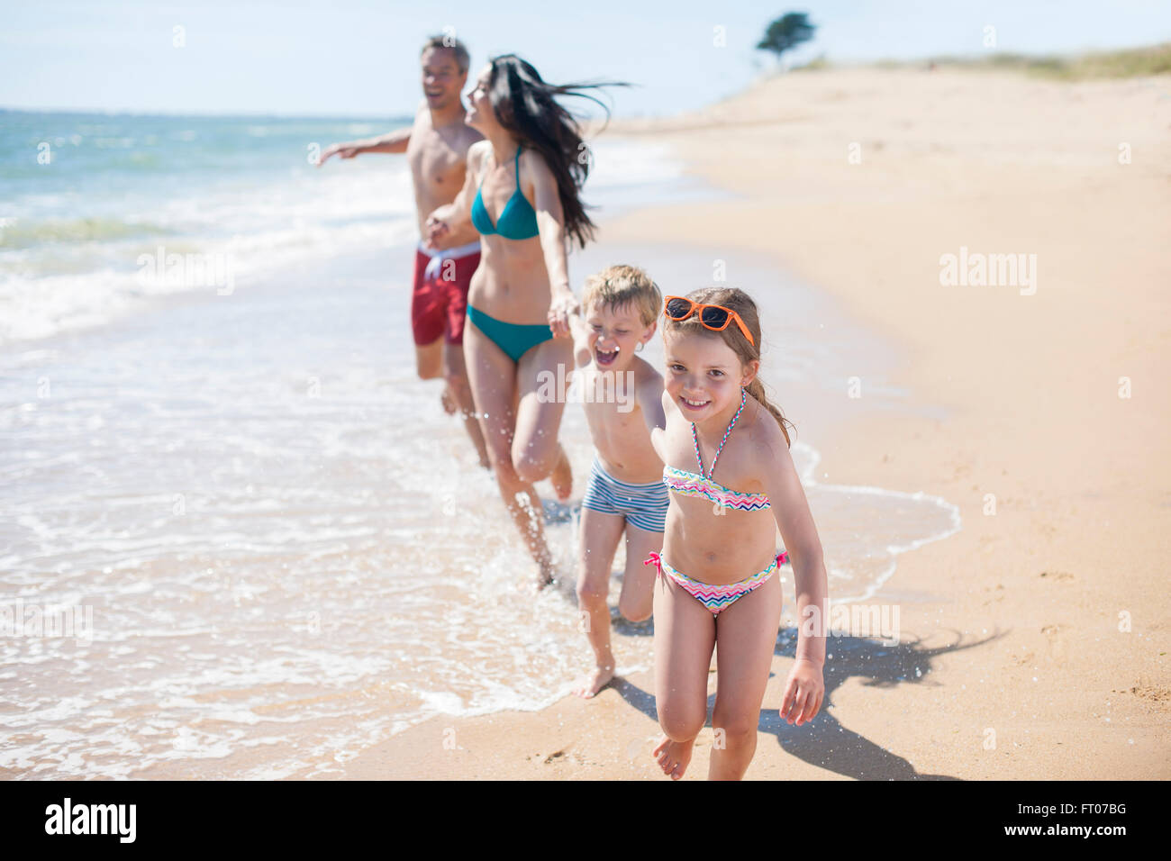 happy family in swimsuit having fun in the beach Stock Photo - Alamy