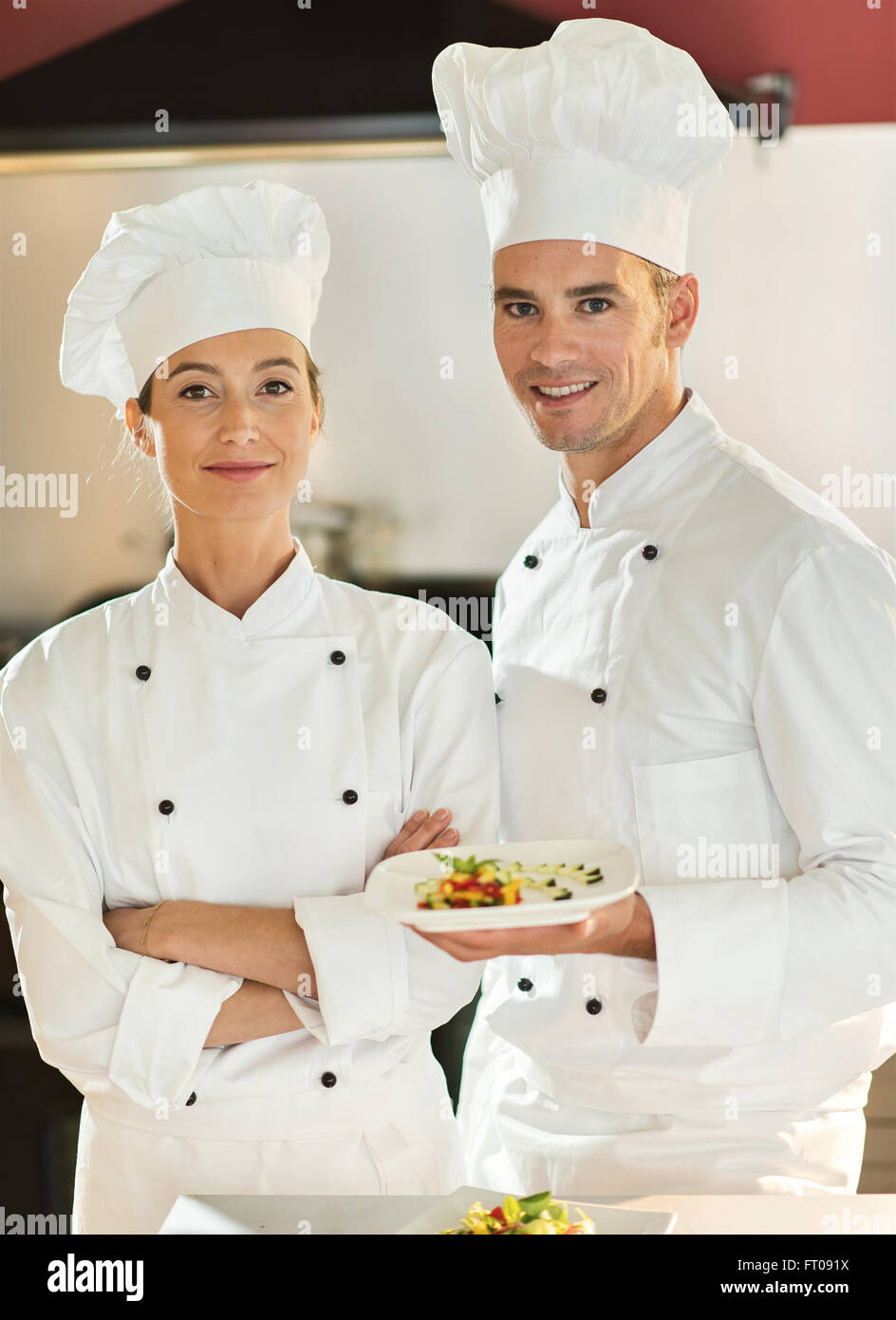 Two chefs in their forties are standing in a professional kitchen