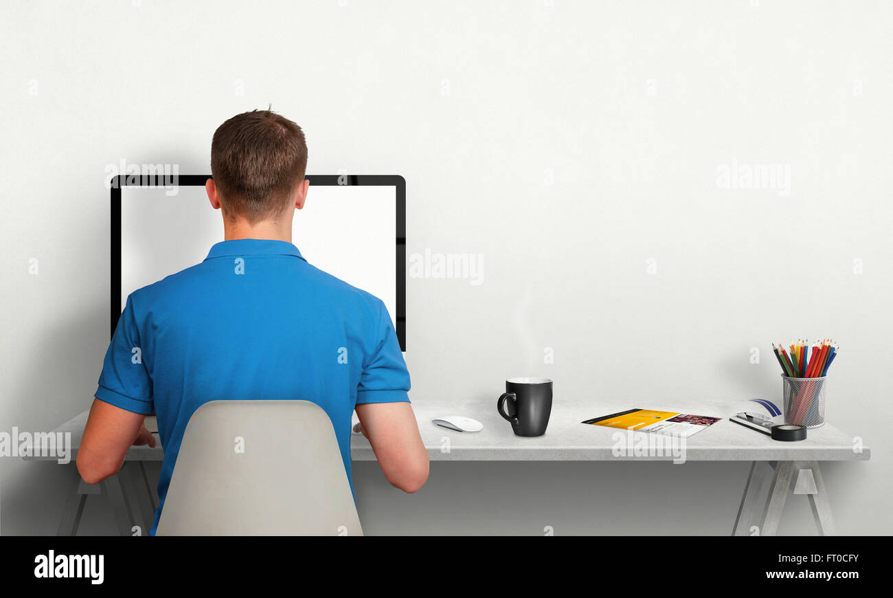 Man working on computer with isolated screen in office interior. Work desk with keyboard, mouse, cup of coffee, paper, pencils. Stock Photo