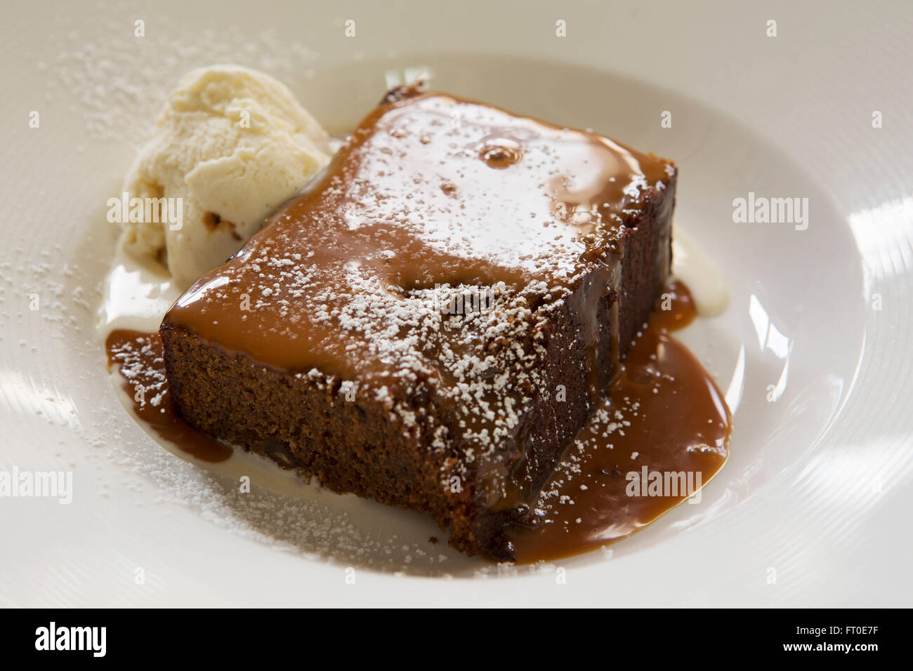 Sticky toffee pudding served with vanilla ice cream in London, England