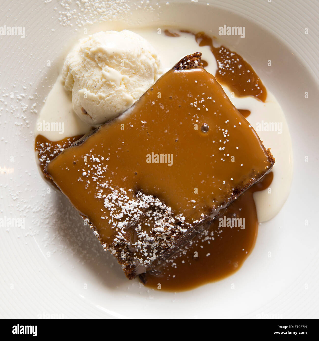 Sticky toffee pudding served with vanilla ice cream in London, England