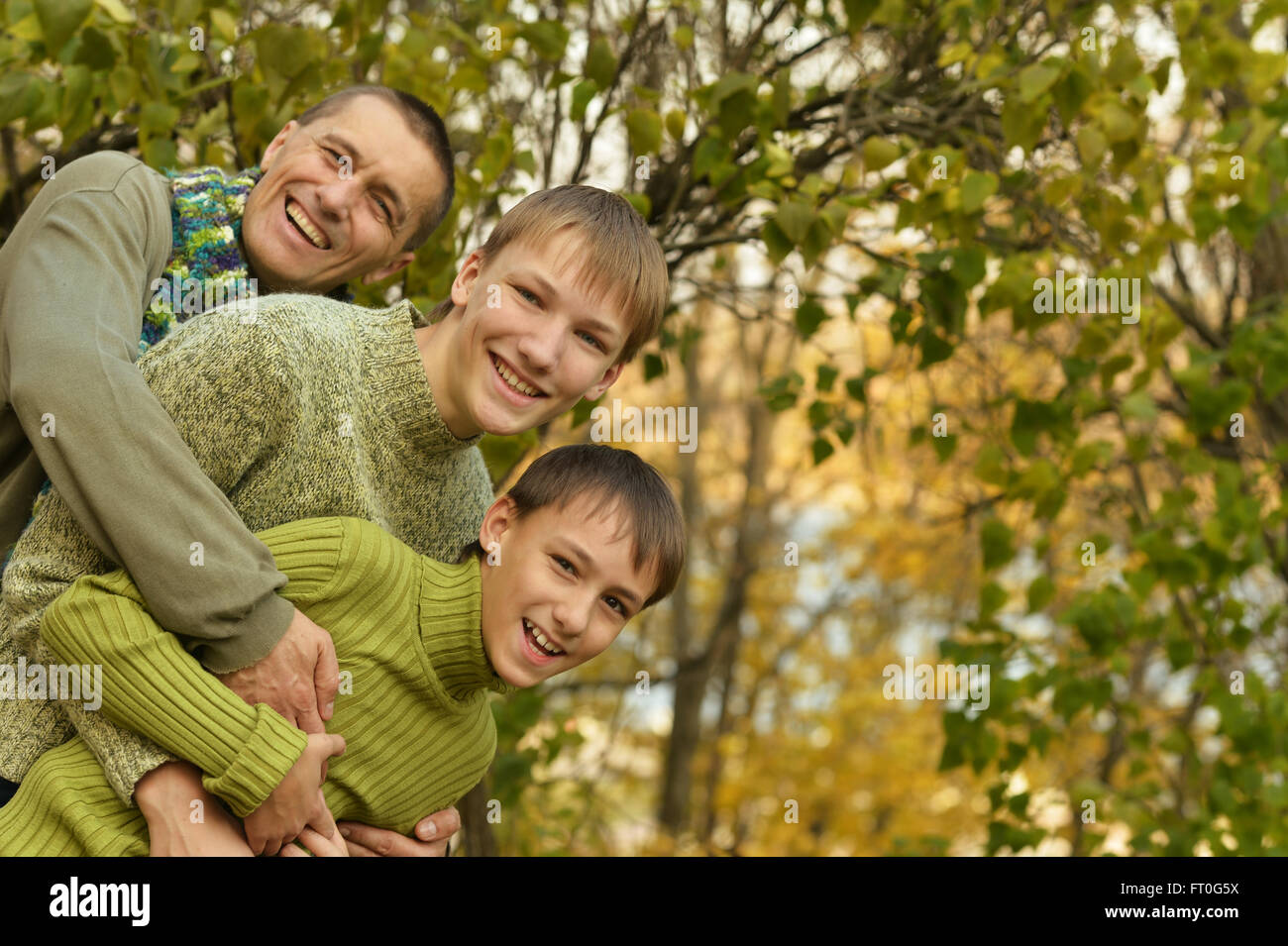 Father and sons in autumn park Stock Photo - Alamy