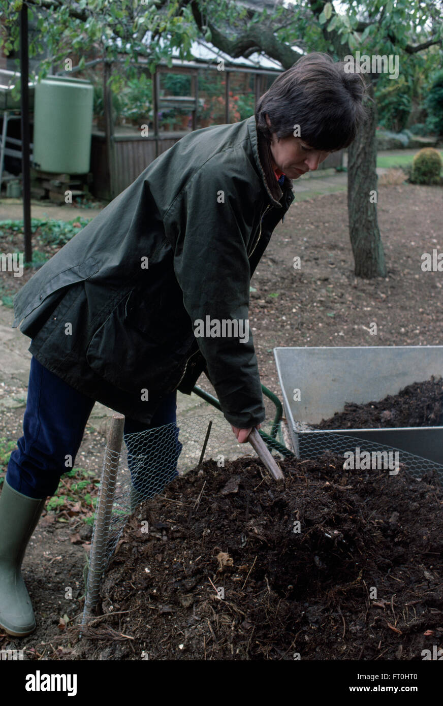 Woman turning compost in a compost heap FOR EDITORIAL USE ONLY Stock