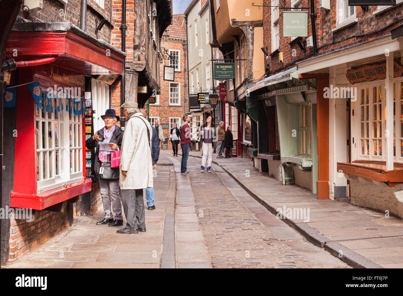 Senior couple shopping in The Shambles, York, North Yorkshire, England, UK   Slight motion blur on woman's face at large sizes. Stock Photo