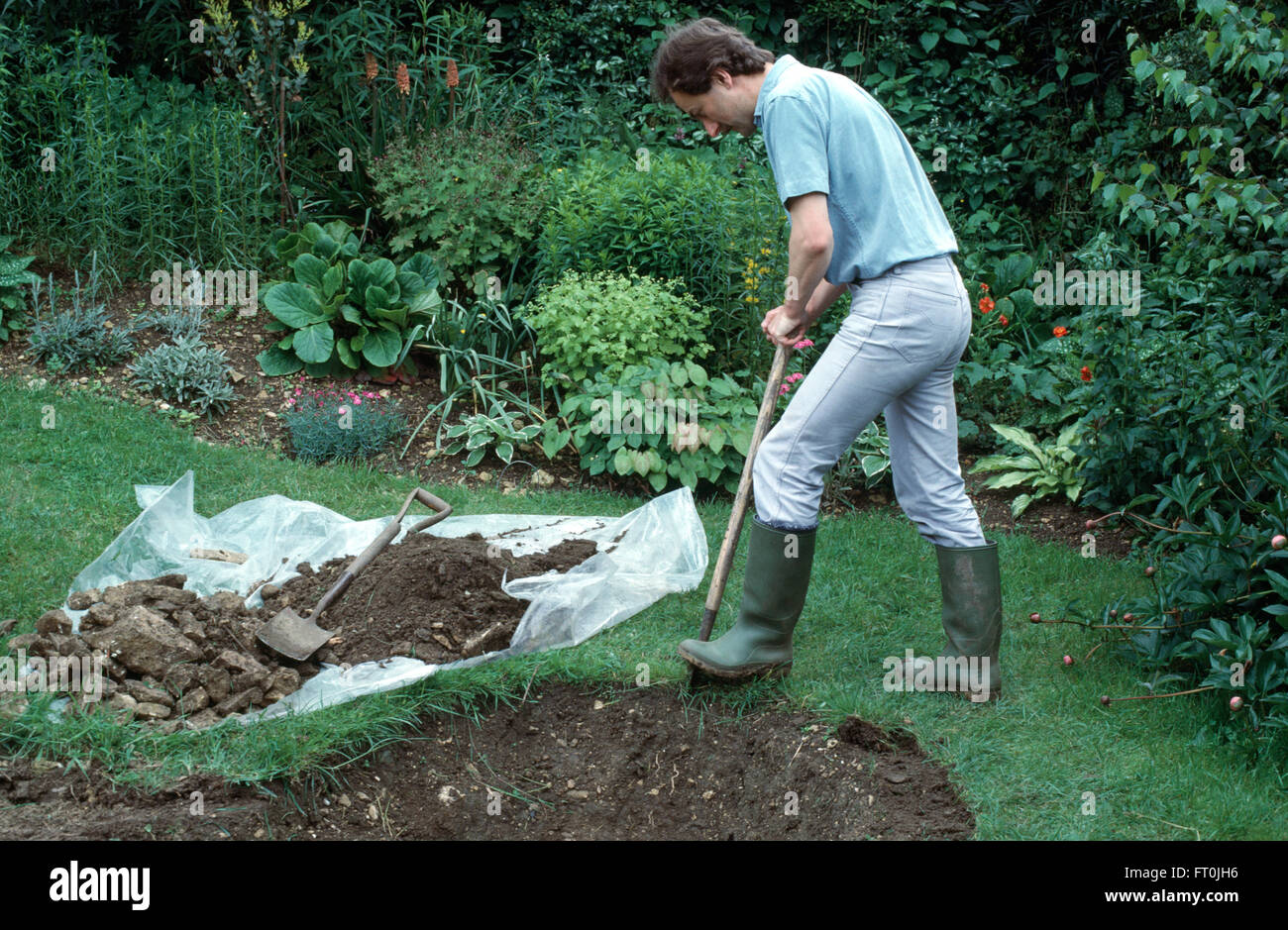 Gardener digging out measured area in lawn for a new pond         FOR EDITORIAL USE ONLY Stock Photo