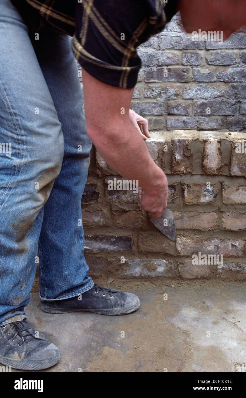 Close-up of a workman building a low wall     FOR EDITORIAL USE ONLY Stock Photo