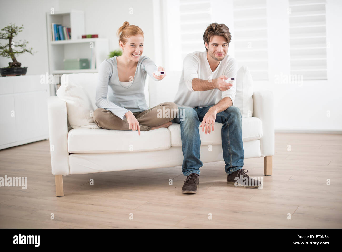 cheerful couple play to video game on a couch Stock Photo