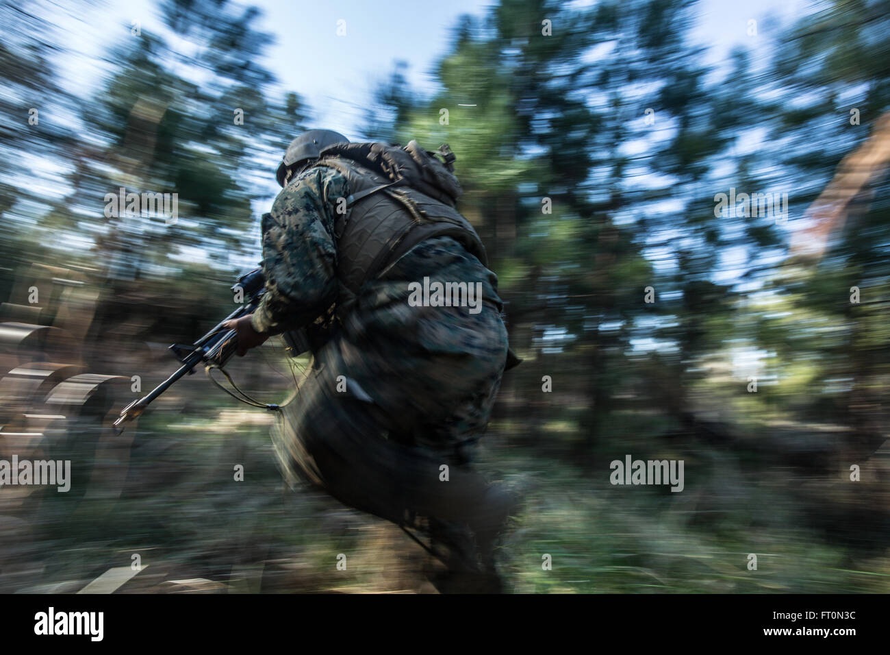 A U.S. Navy Corpsman assigned to Field Medical Training Battalion East (FMTB-E), responds to a simulated attack during a final exercise (FINEX) at Camp Johnson, N.C., March 2, 2016. FINEX is a culminating event at FMTB-E which transitions Sailors into the Fleet Marine Force. (U.S. Marine Corps photo by Sgt. James R. Skelton/Released) Stock Photo