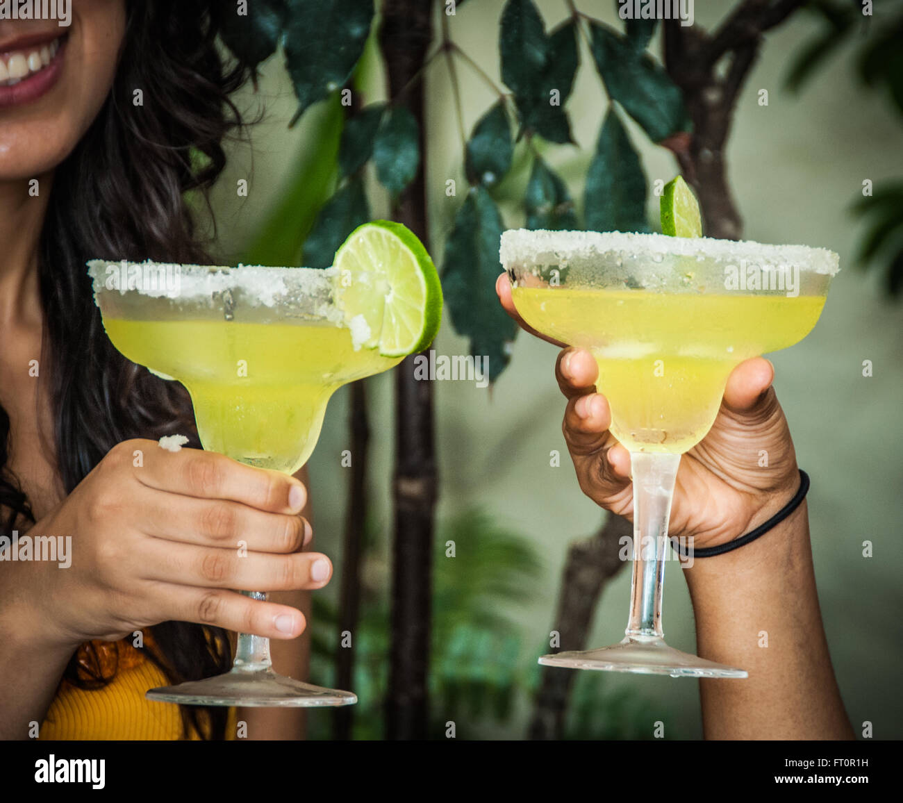 2 Young Mexican women toast with margarita drinks Puerto Vallarta