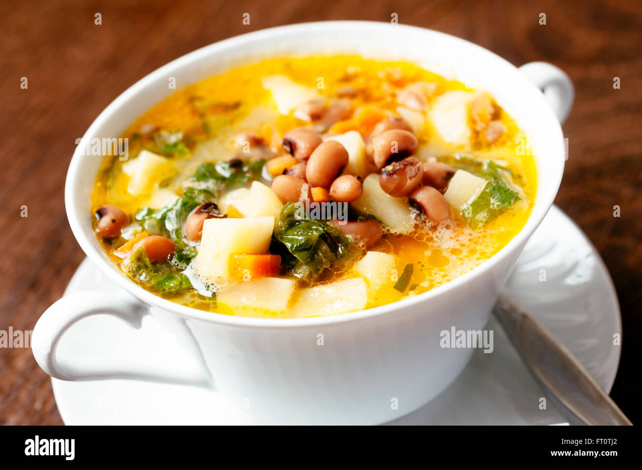 Bowl with a parsnip, escarole endive and black-eyed bean soup. Stock Photo