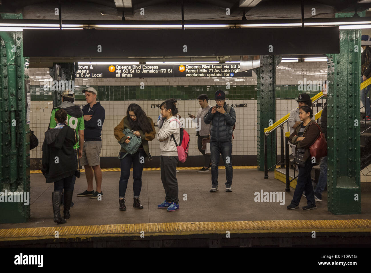 Riders wait for a subway train at the West 4th St. Station in Greenwich