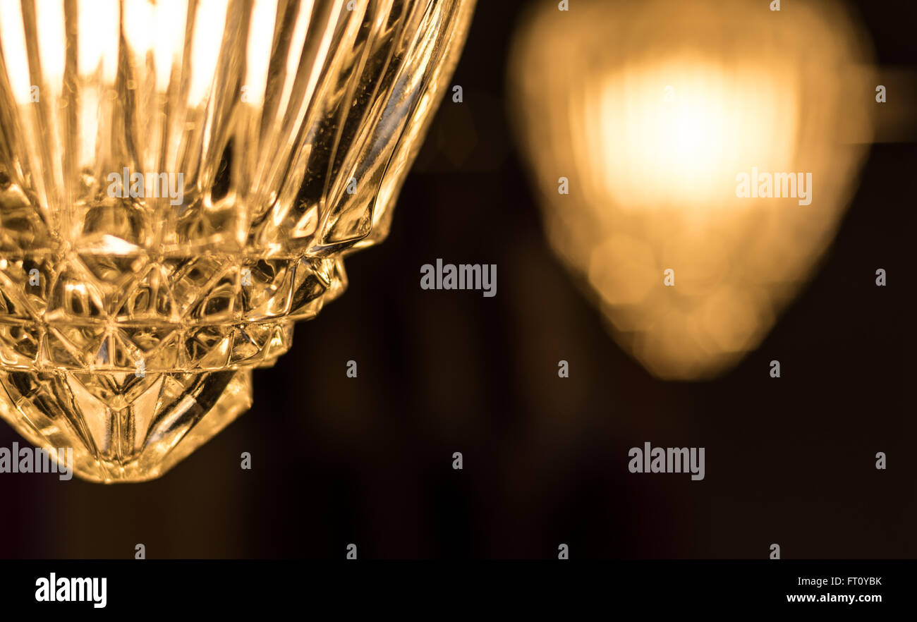 Detail of a crystal style glass cover which adorns a hanging chain link, swag style lamp in a bathroom. Stock Photo