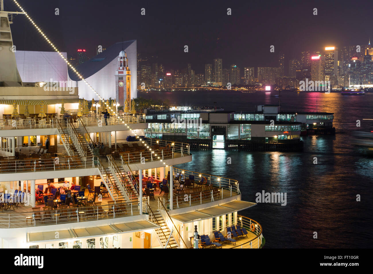 Cruise ship MS Deutschland, Reederei Peter Deilmann, at Ocean Terminal with skyline across Hong Kong Harbour at night, Tsim Sha Tsui, Kowloon, Hong Kong Stock Photo