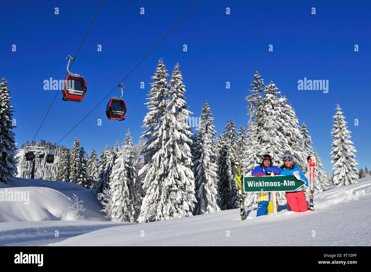 Skiers posing behind a signpost, Winklmoosalm ski area, Reit im Winkl, Chiemgau, Bavaria, Germany Stock Photo