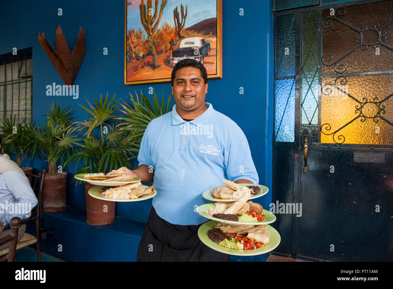 Waiter serving plates with Mexican food in a hotel restaurant, Todos