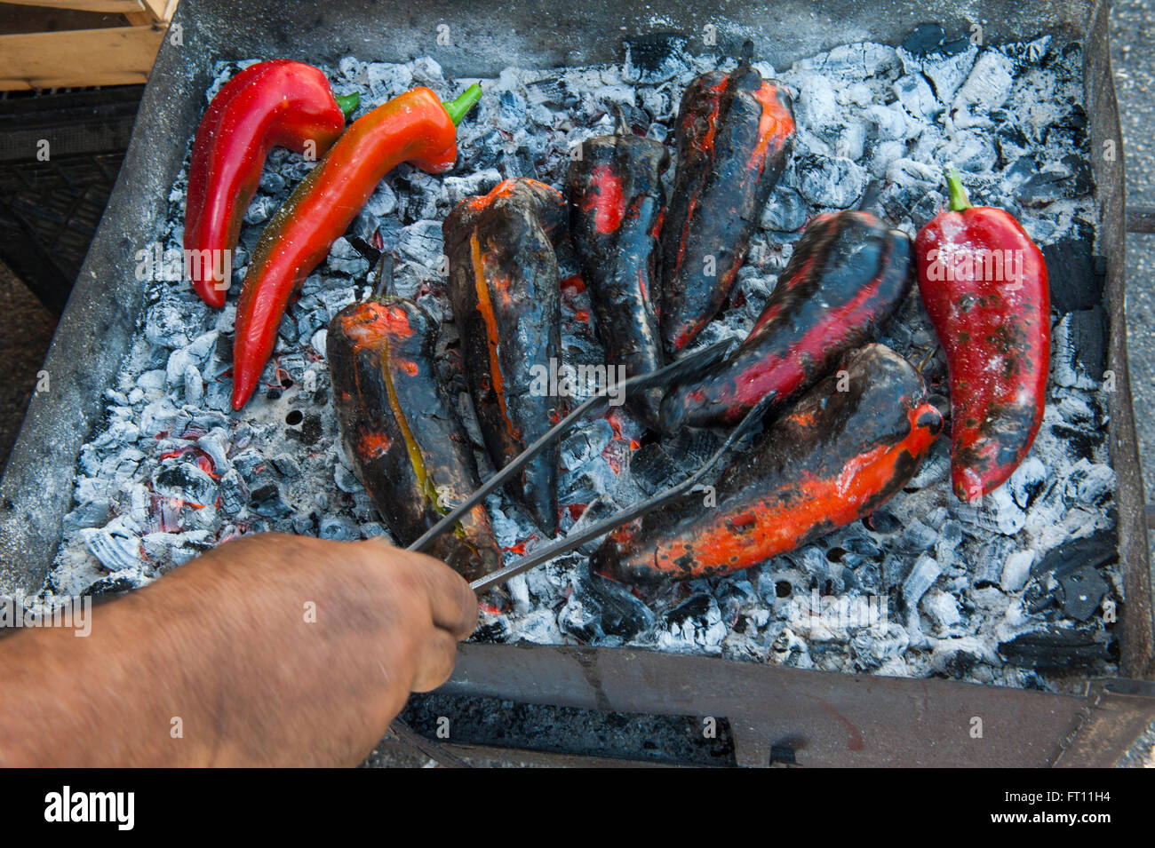 Barbecuing of paprika peppers at market stand, Syracuse, Sicily Stock Photo