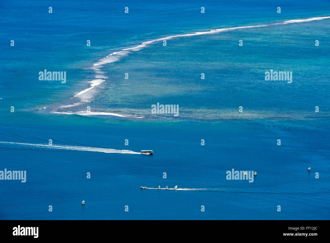 People enjoying watersports along a reef near Cook's Bay, Moorea, French Polynesia, South Pacific Stock Photo