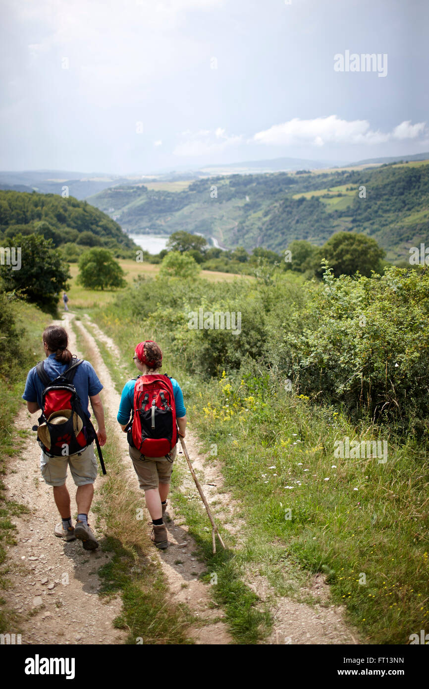 Hikers passing a path crossing a meadow, Rhineland-Palatinate, Germany Stock Photo