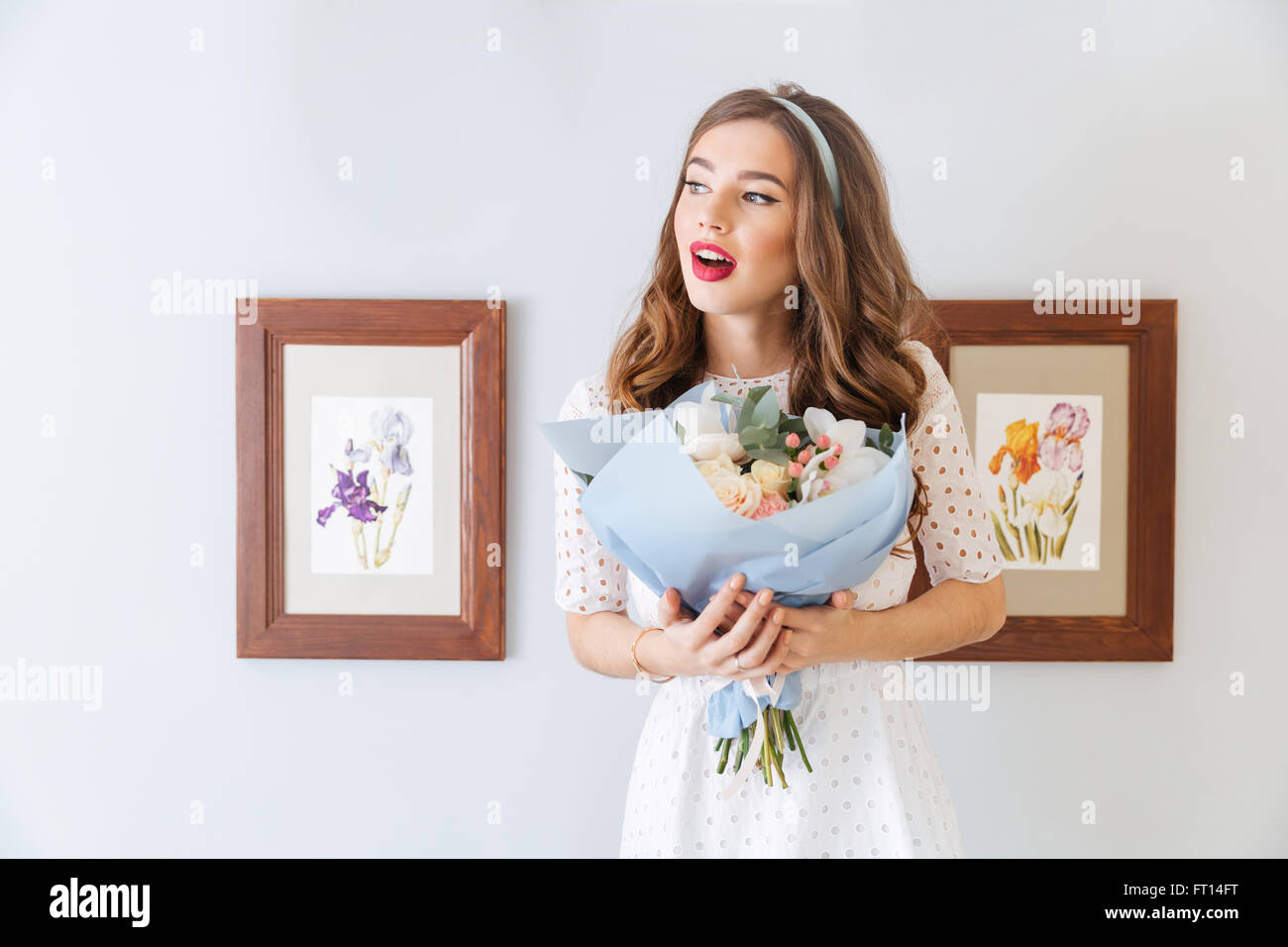 Pensive charming young woman holding bouquet of flowers Stock Photo - Alamy
