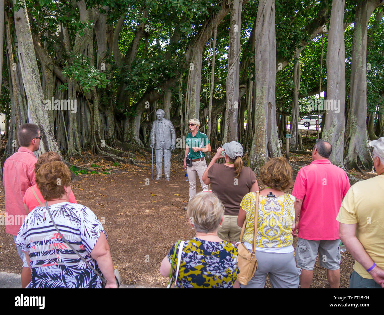Tourist listening to talk at Thomas Edison statue and Banyan tree at Edison and Ford Winter Estates in Fort Myers Florida Stock Photo