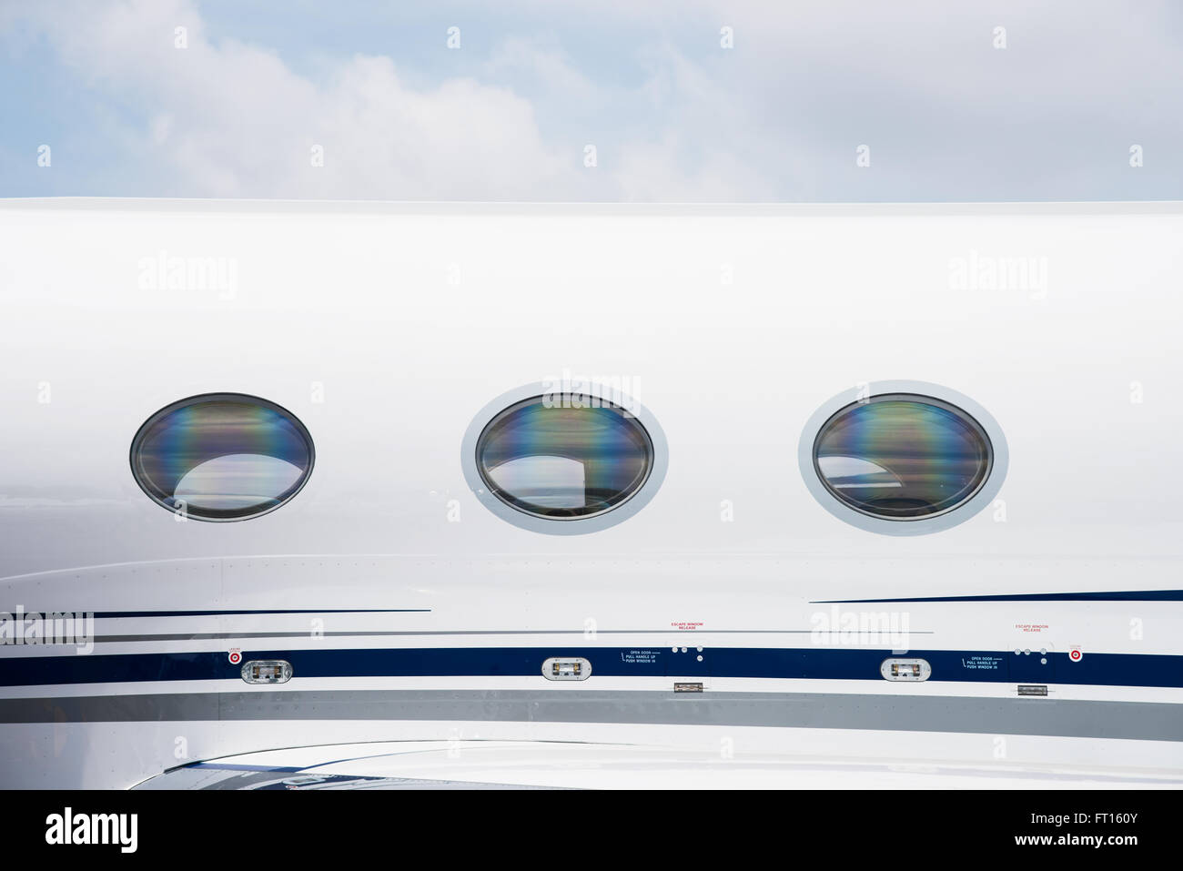 Windows and fuselage detail of white business jet aircraft. Stock Photo