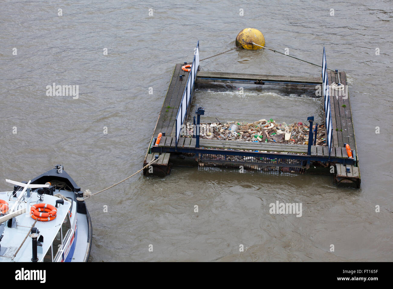 A rubbish collecting barge floating on the river thames London, rubbish