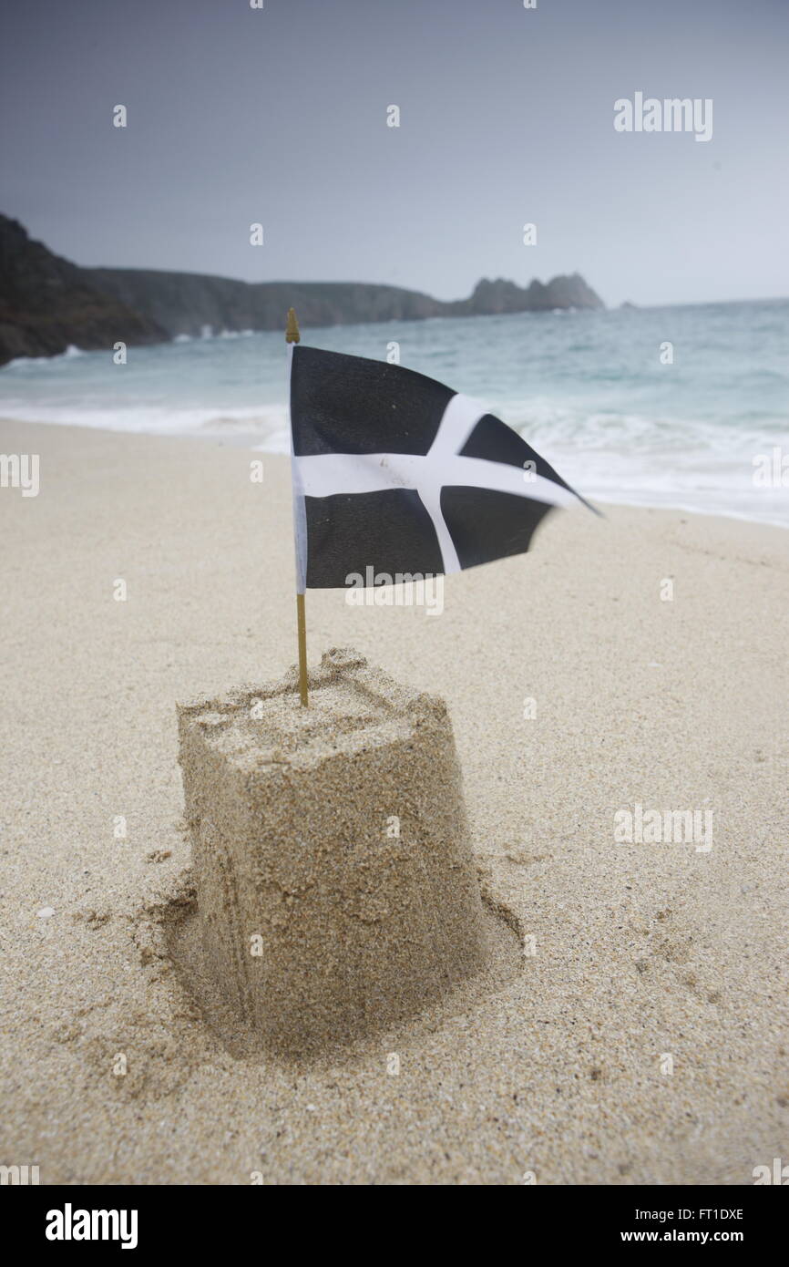 A sandcastle with the cornish flag on a beach in cornwall Stock Photo