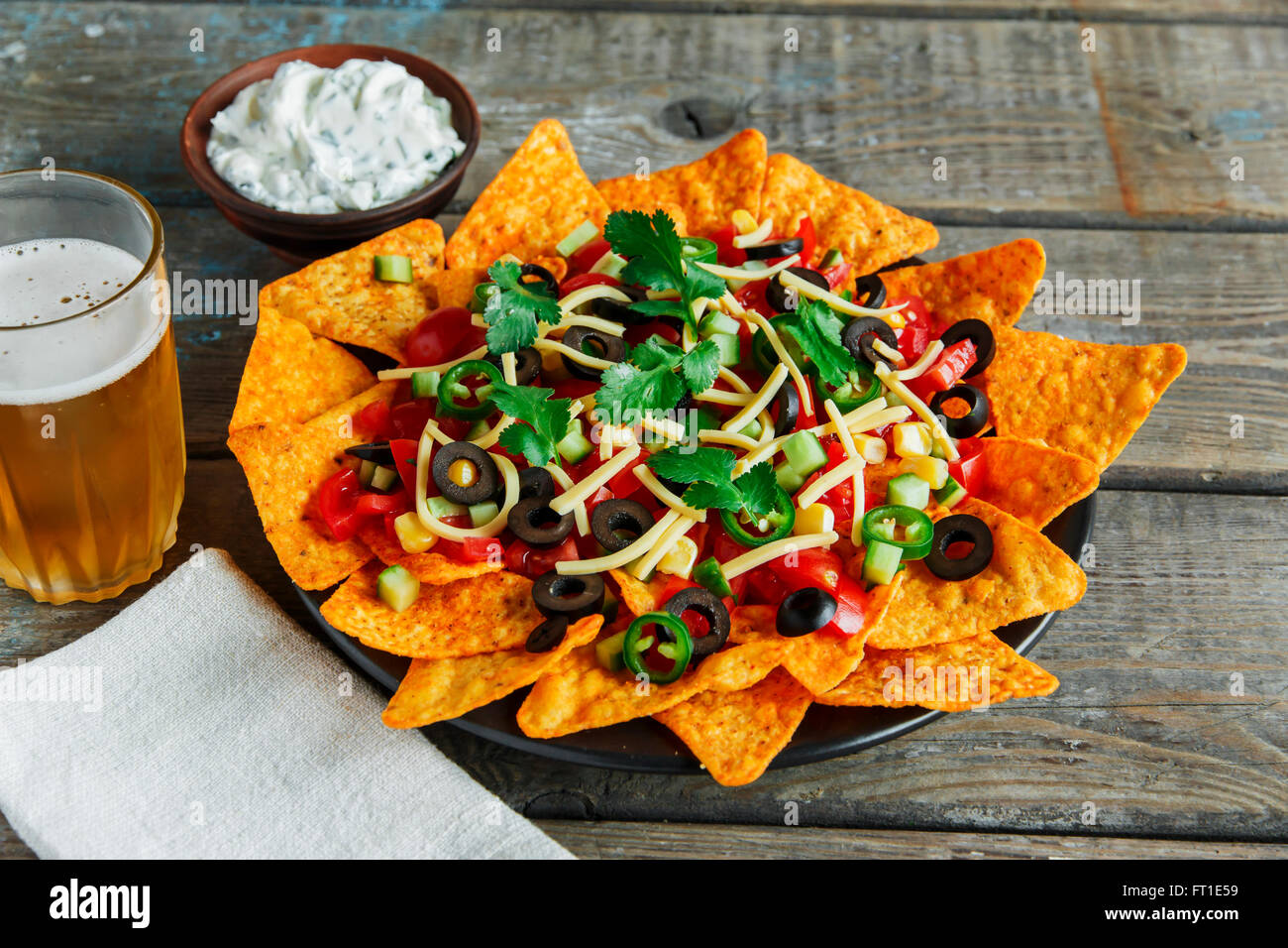 mexican tortilla chips with cheese tomato black olives pepper sauce Stock Photo
