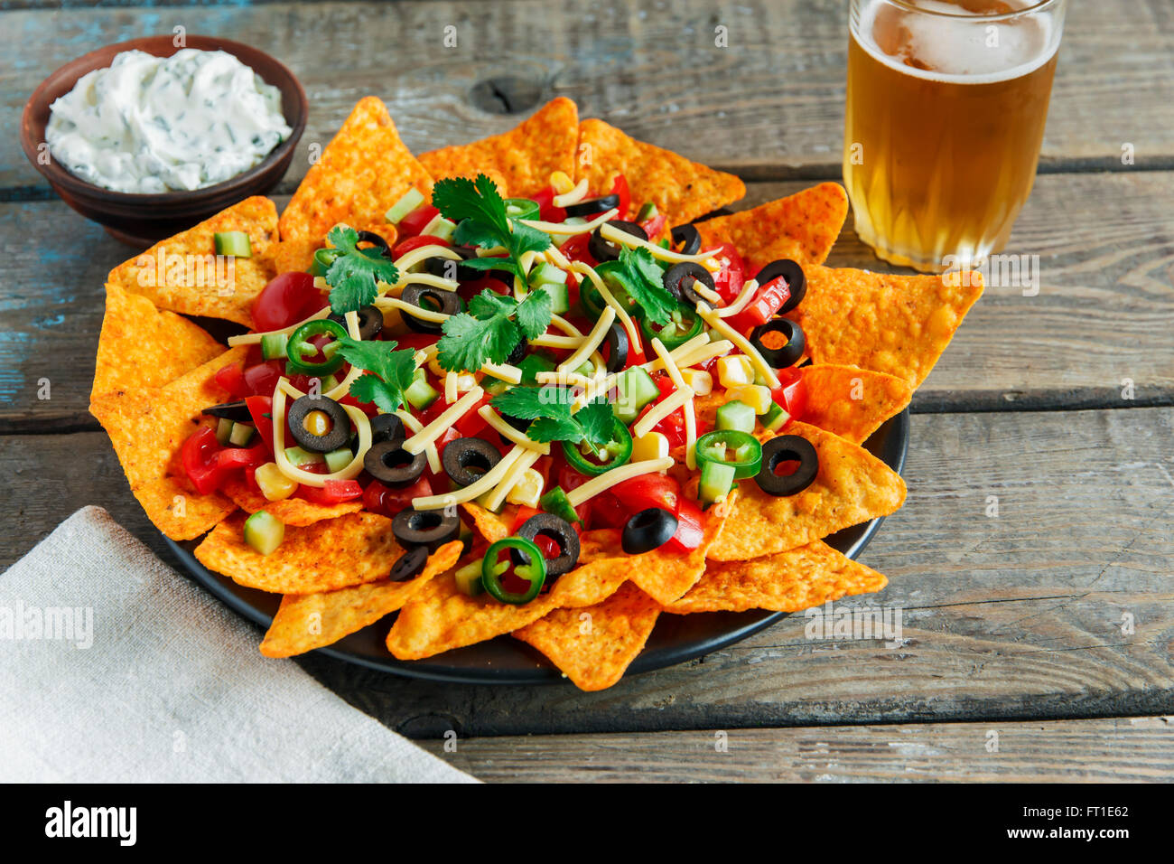 mexican tortilla chips with cheese tomato black olives pepper sauce Stock Photo